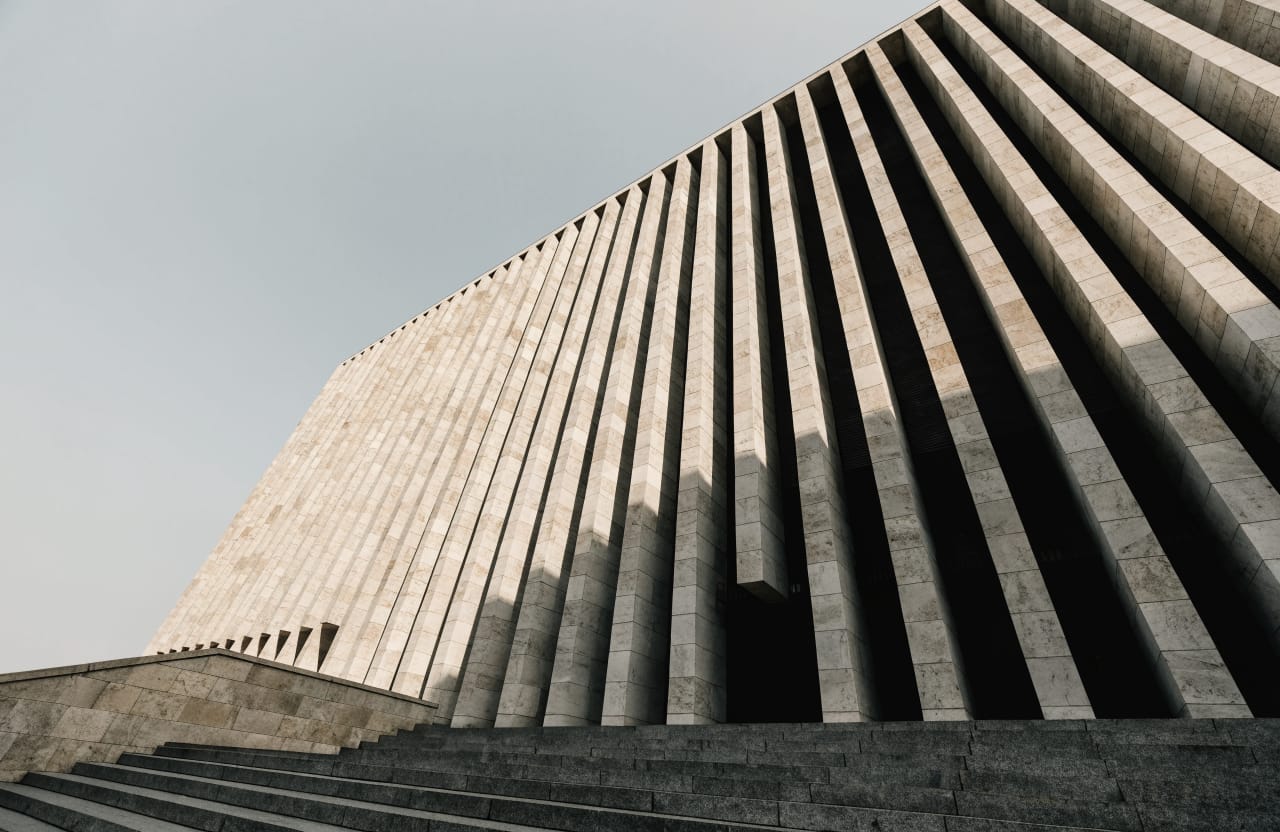 Low angle view of a modern courthouse with a vertical stone facade