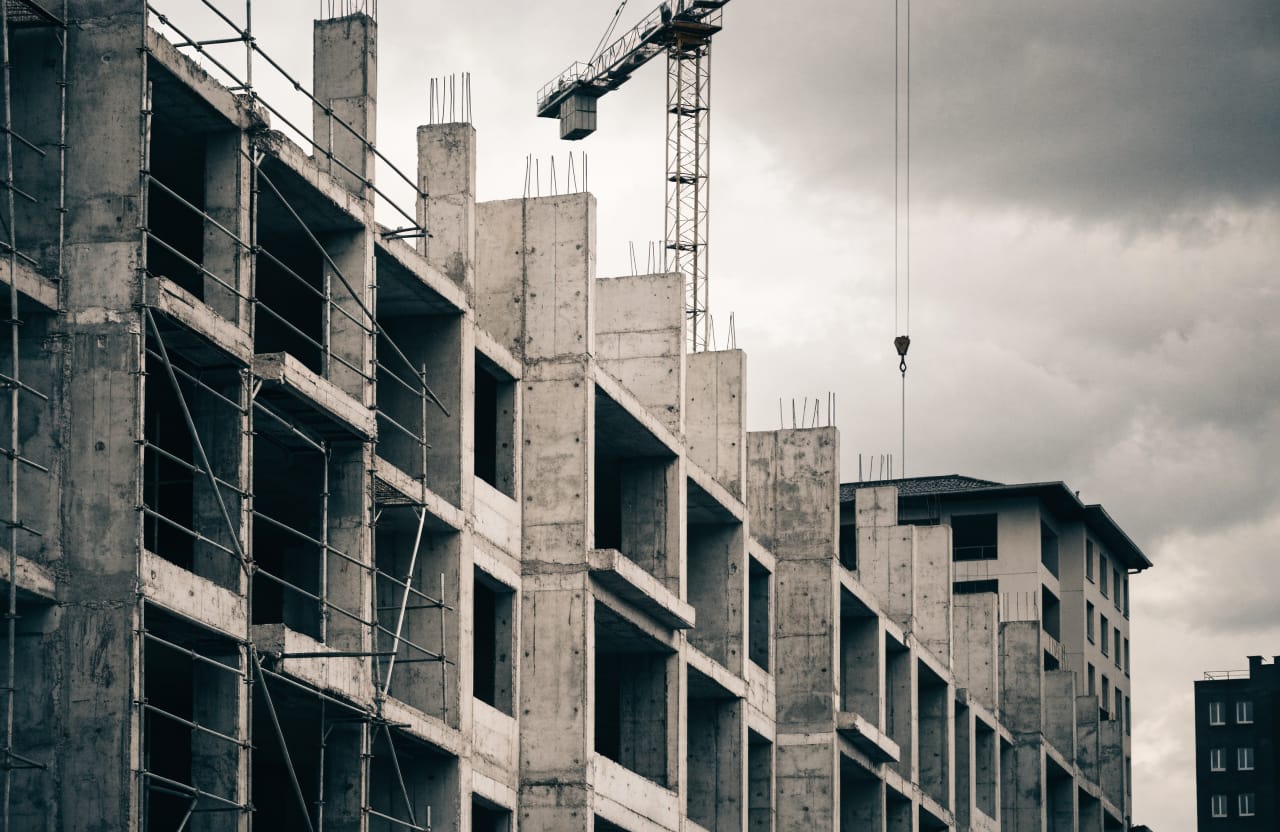 Reinforced concrete construction with exposed columns and formwork, a crane above