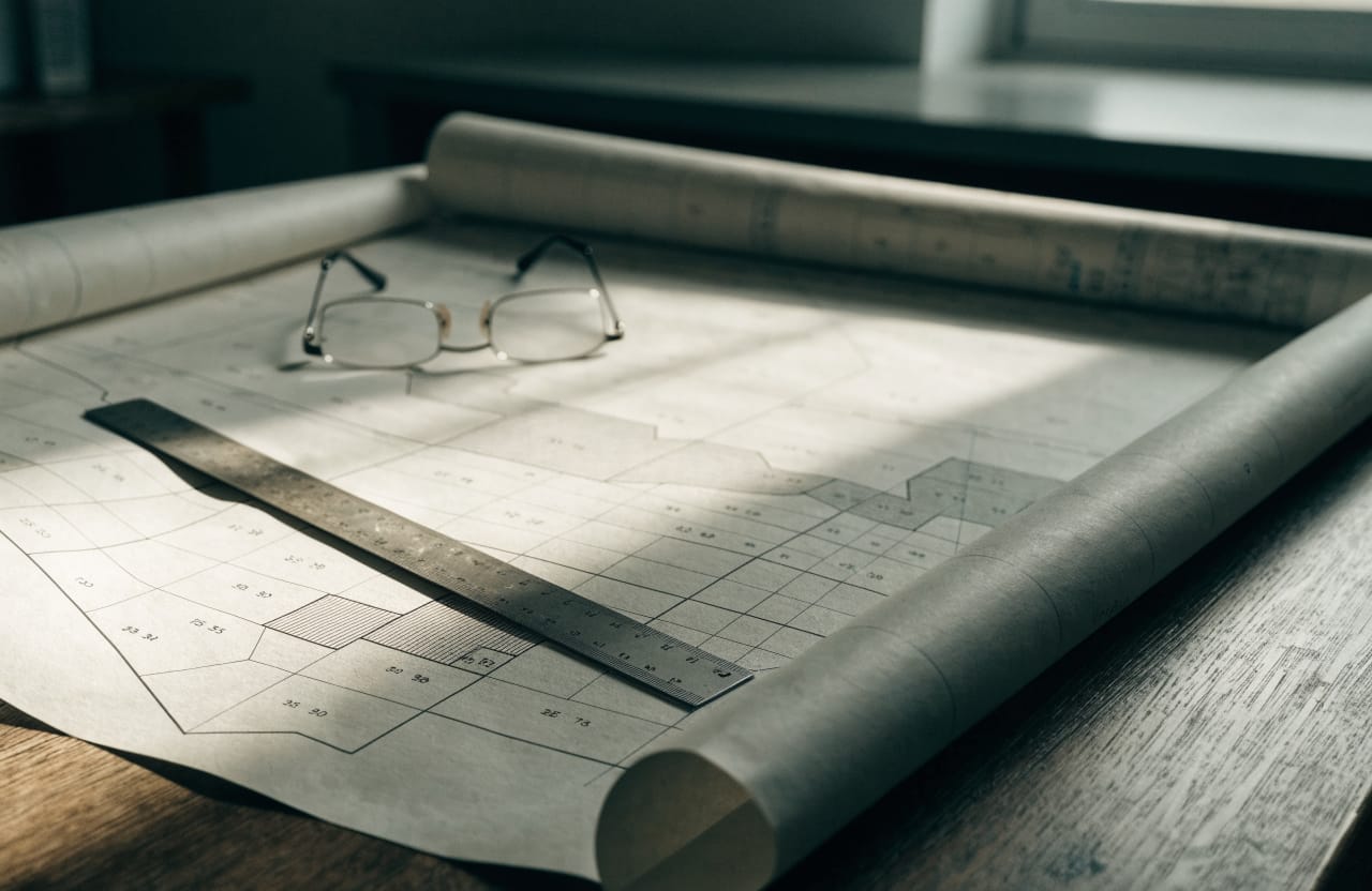 Cadastral sheet spread over a table, showing parcel boundaries and numbers
